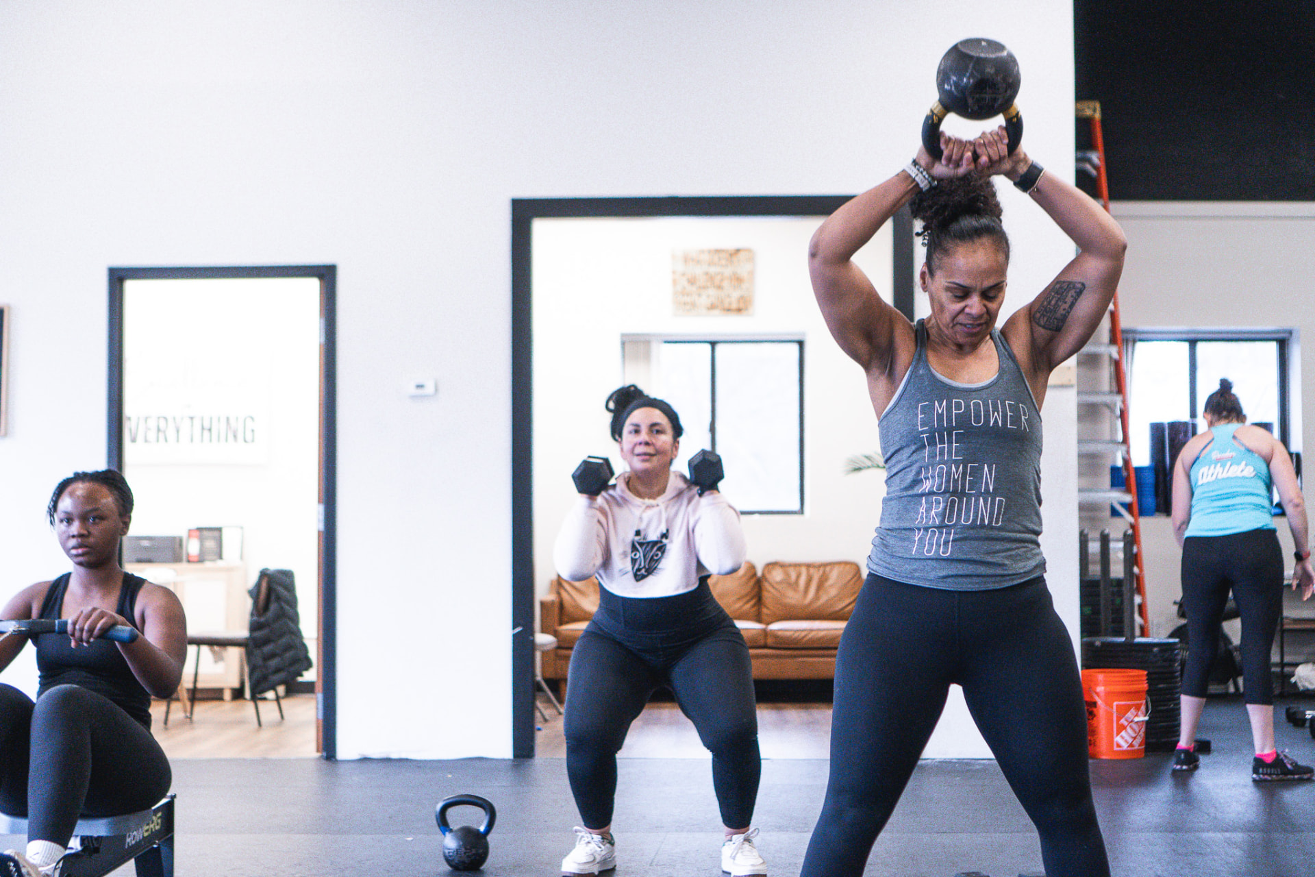 Employees working through a coached kettlebell and dumbbell session